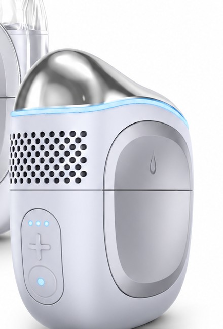 Close-up of the facial device with its stainless steel head, blue light ring and plus button with three level lights